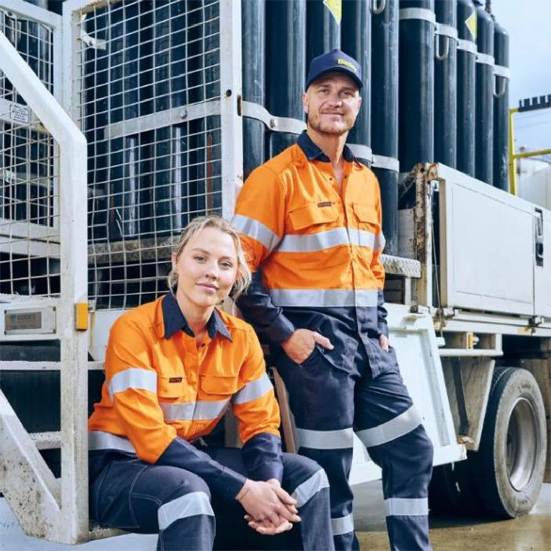 A photograph showcasing a variety of uniforms made from durable fabrics in a warehouse setup.